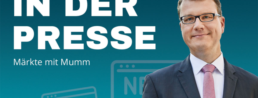 Mann im Anzug mit Brille vor einem blauen Hintergrund mit der Aufschrift "IN DER PRESSE - Märkte mit Mumm" und stilisierten Zeitungs-Icons.