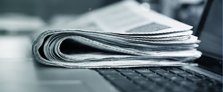 Eine gefaltete Zeitung liegt auf einer Laptop-Tastatur.
