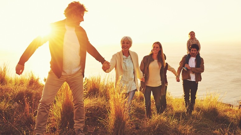 Purpose-Zukunft-Horizonte-Beileger 2025 Das Bild zeigt eine Familie mit Kindern und Oma, die sich an den Händen haltend bei Sonnenuntergang gemeinsam einen Berg bewandert