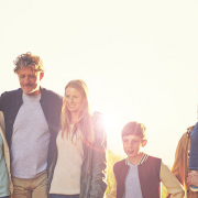 Das Bild zeigt eine fröhliche Familie mit Vater, Mutter, Kind und Großmutter bei einem gemeinsamen Nachmittagsspaziergang durch die Natur.